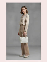 CrossKulture - BlissMagic white lightweight handbag carried by female model