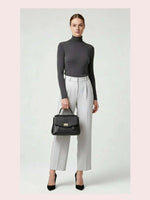 CrossKulture - BlissPulse black lightweight handbag carried by female model