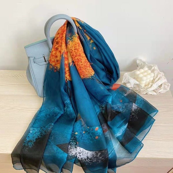 CrossKulture - OceanWhisper Long Chiffon Scarf Teal Orange placed on a bag view
