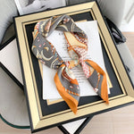 CrossKulture - SmokyBlaze Small Square Satin Scarf Orange placed on a frame view