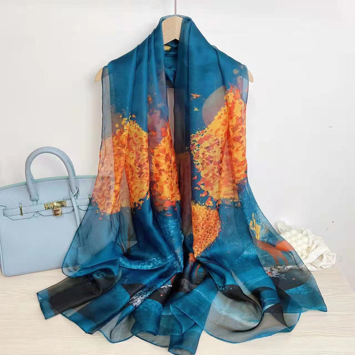 CrossKulture - OceanWhisper Long Chiffon Scarf Teal Orange placed on a hanger view