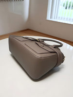 CrossKulture - BlissIcon harm two front pocket beige handbag placed on a table